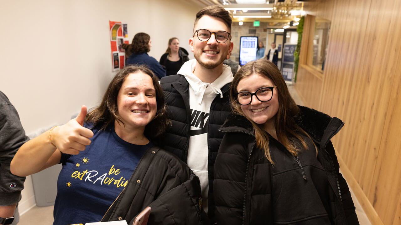 Three students smile and give thumbs up during rec and wellness center opening.