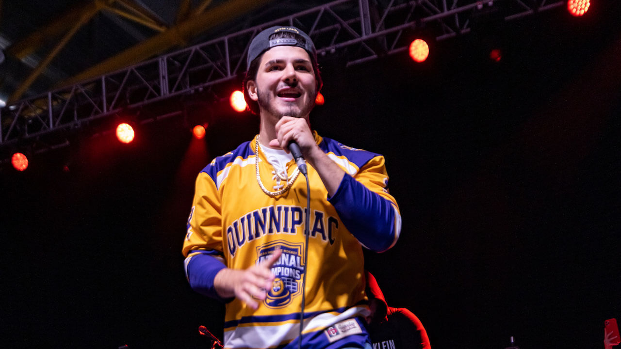 Warm up act performing on stage at Wake the Giant in Quinnipiac National Champions Jersey