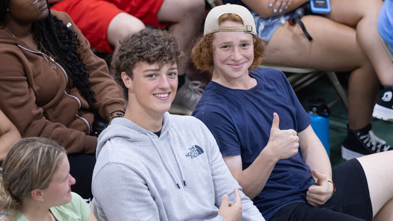 Two students smile and give a thumbs up during the welcome ceremony