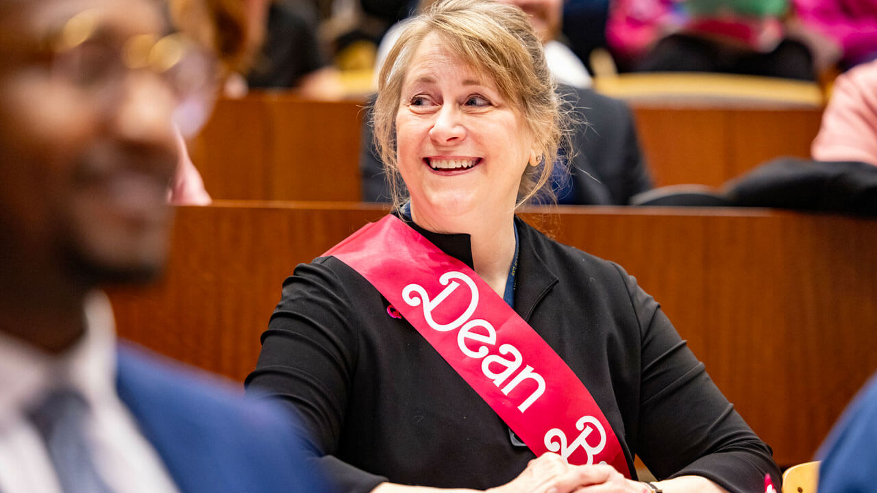 Dean Brown smiling as she sits at the Public Interest Law Project Auction