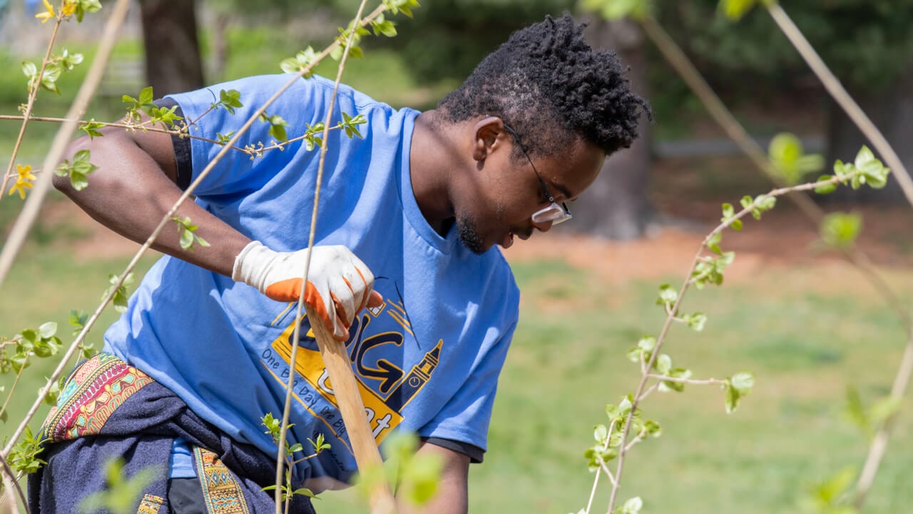 Student uses shovel to dig