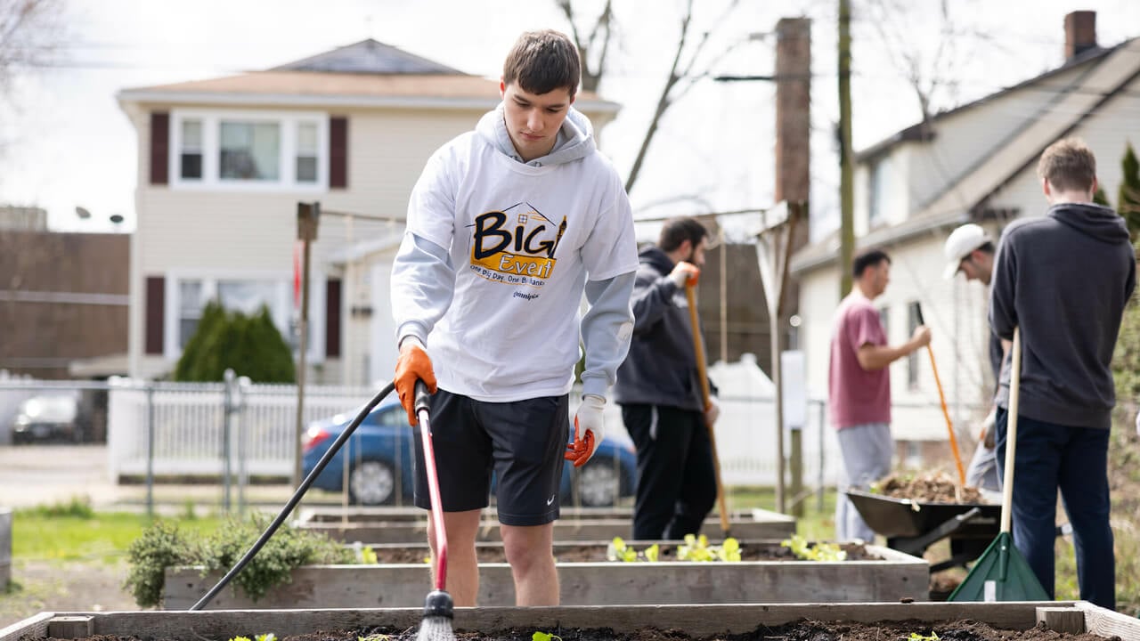 Student waters plants in garden