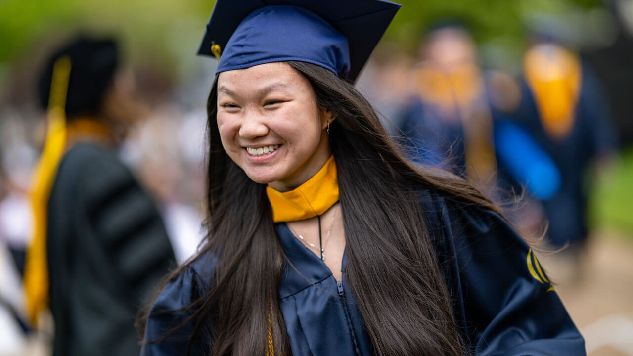 Graduate walking and smiling