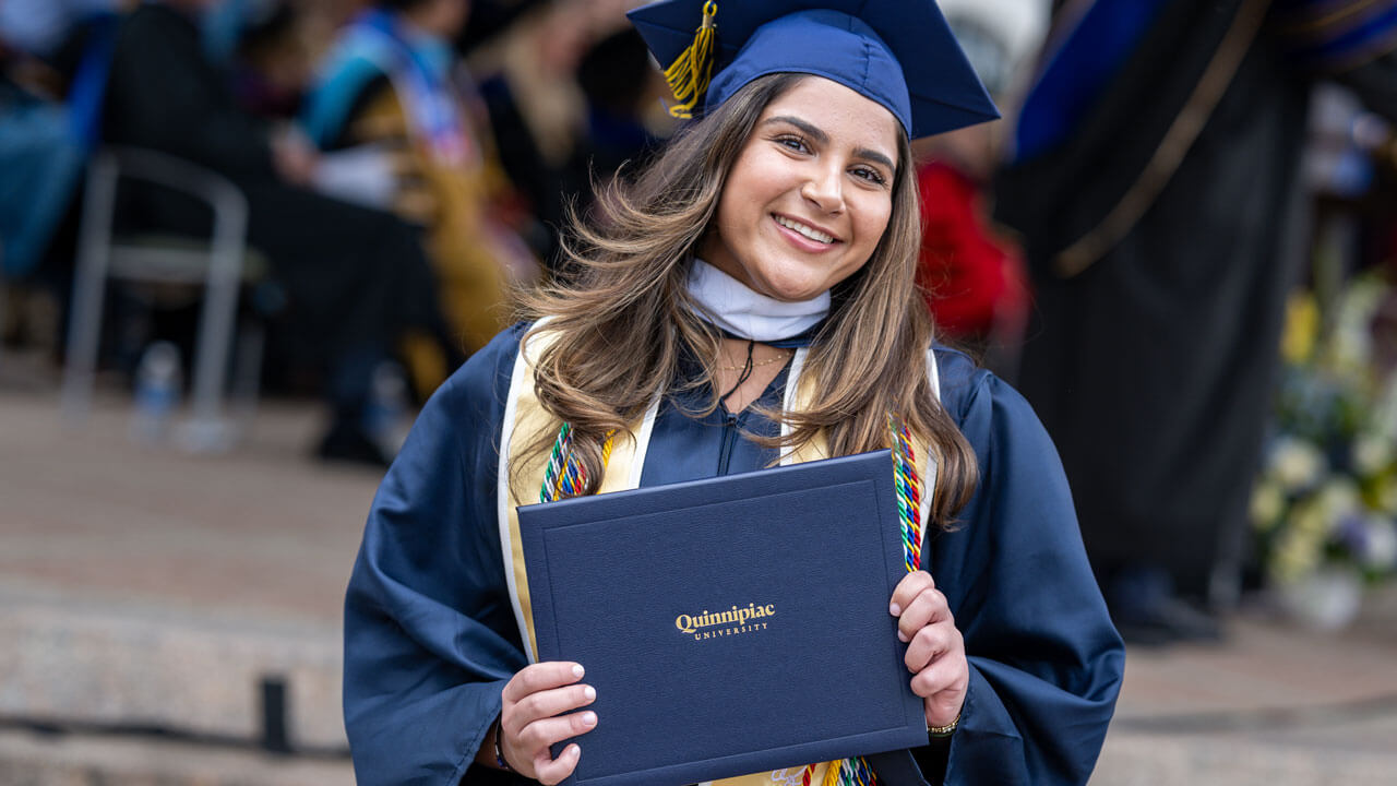 Graduate holding up her degree