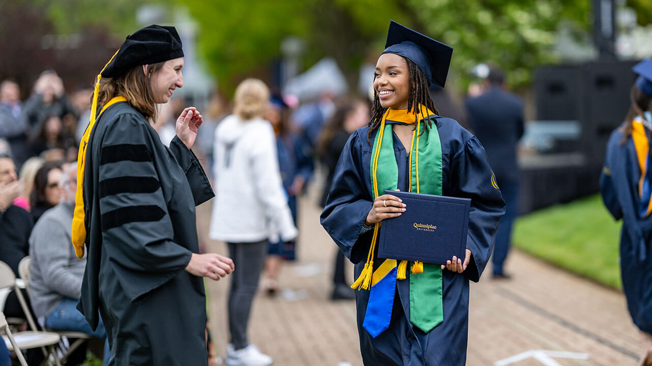 graduate smiles at professor