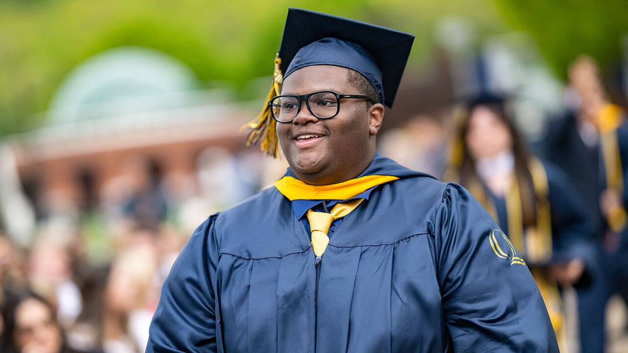 graduate smiles while walking