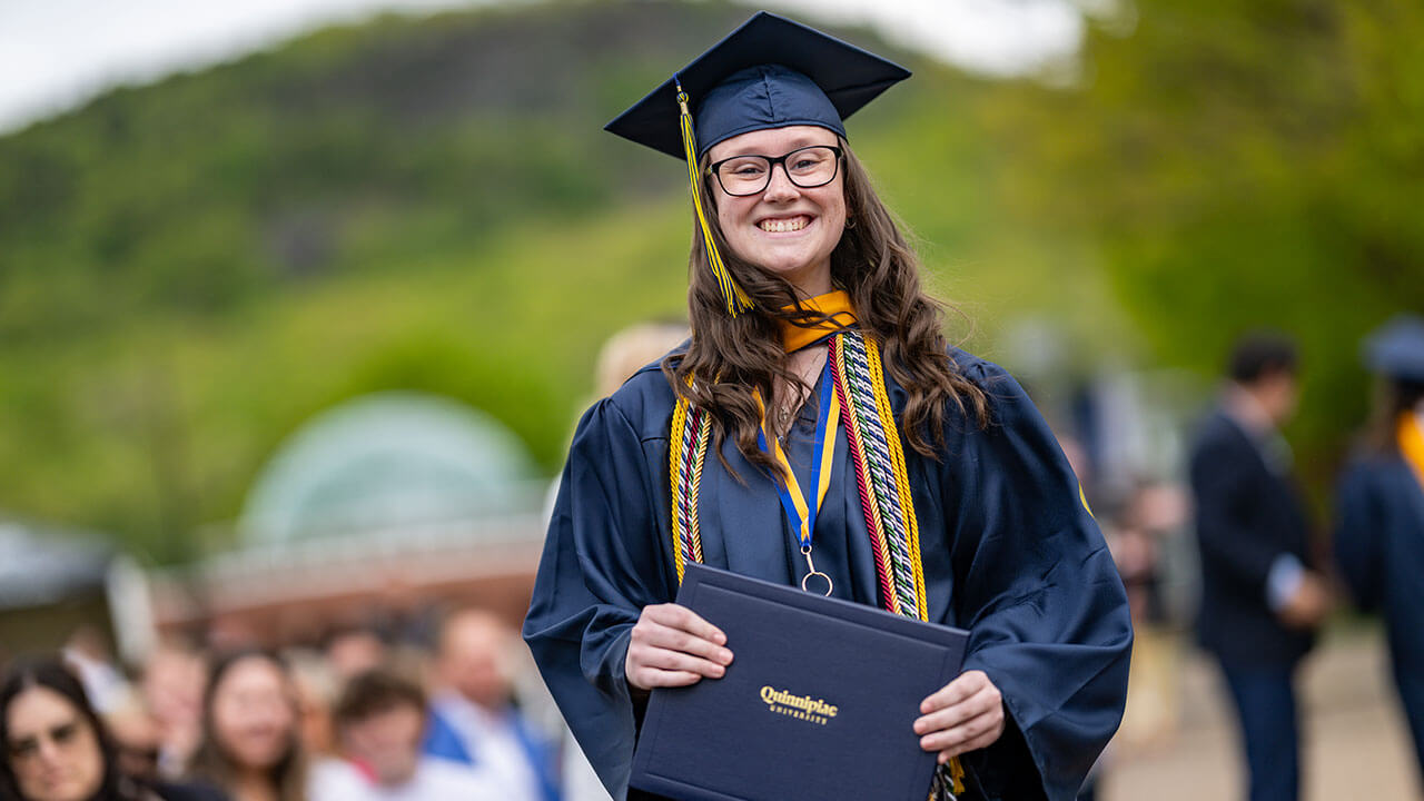 graduate poses with diploma