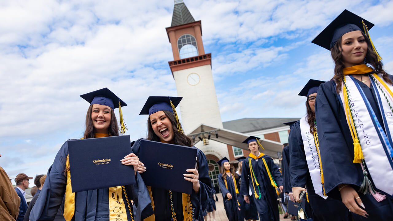 Students smile with degrees