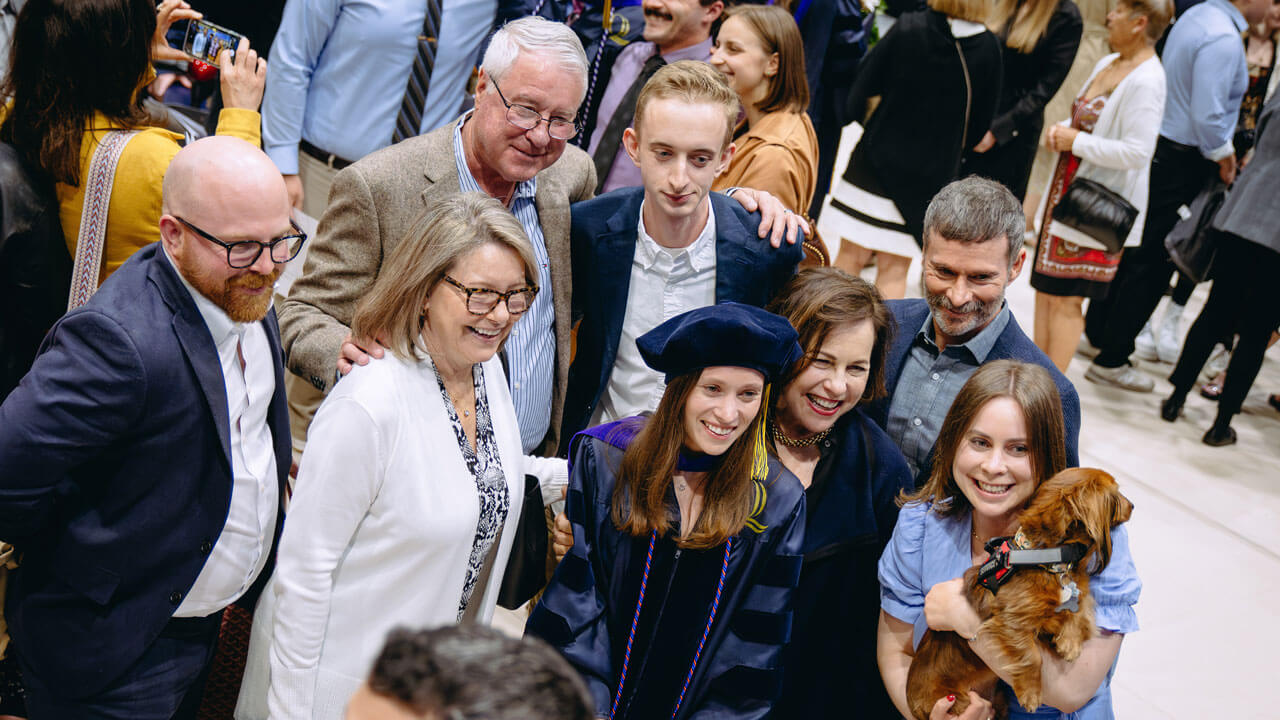 Friends, Family and puppy smiling with a School of Law graduate student