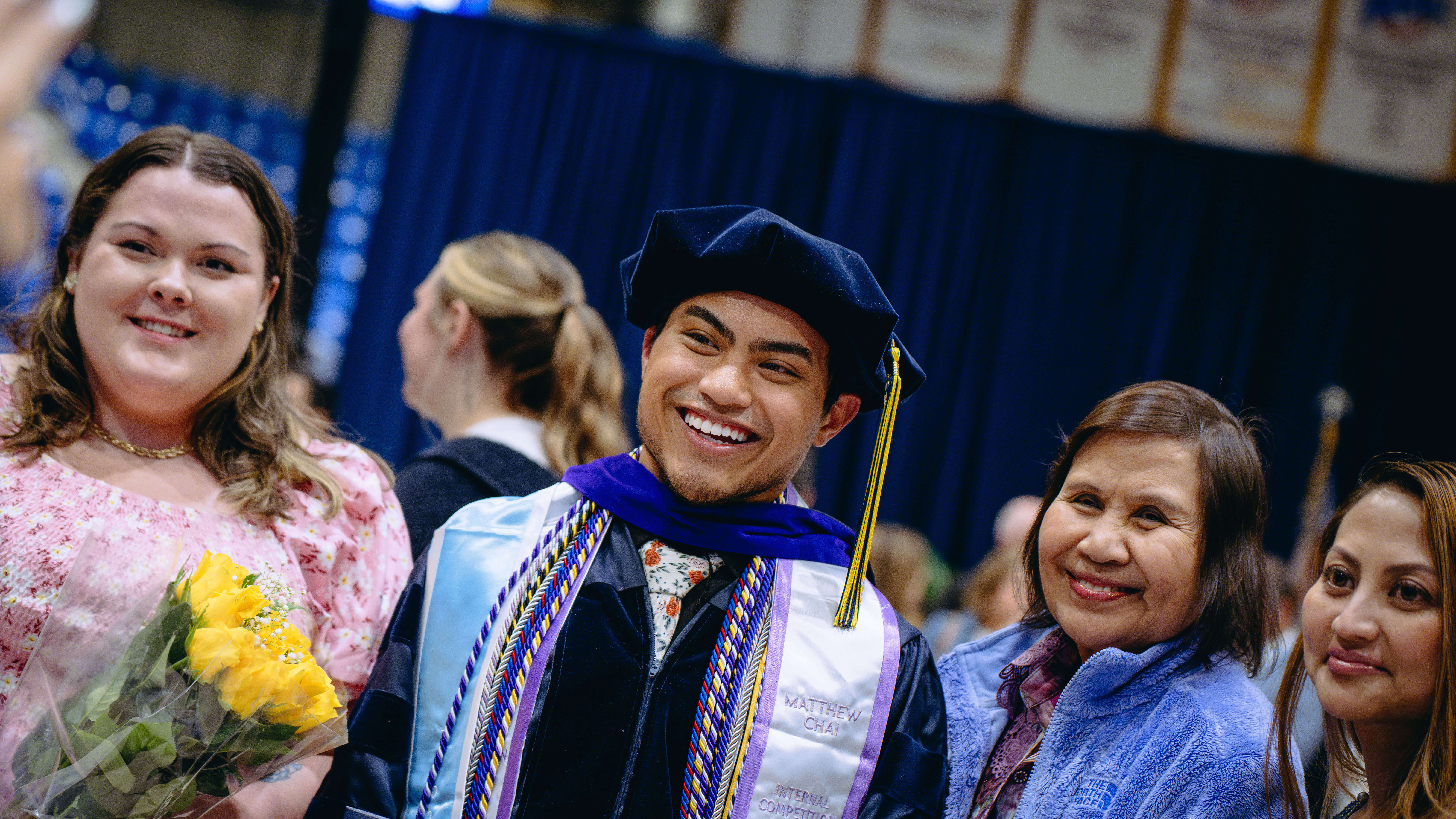 School of Law graduate smiles with his family and friends