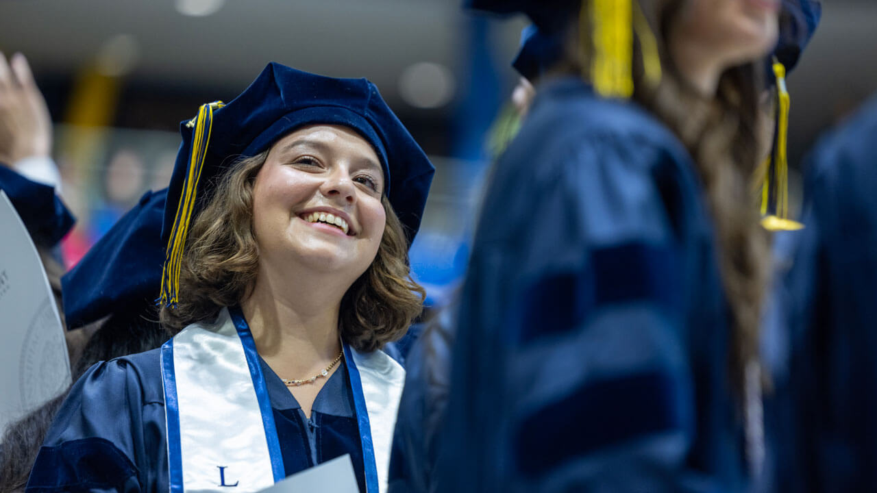 Law graduate from the class of 2024 beams during the ceremony.