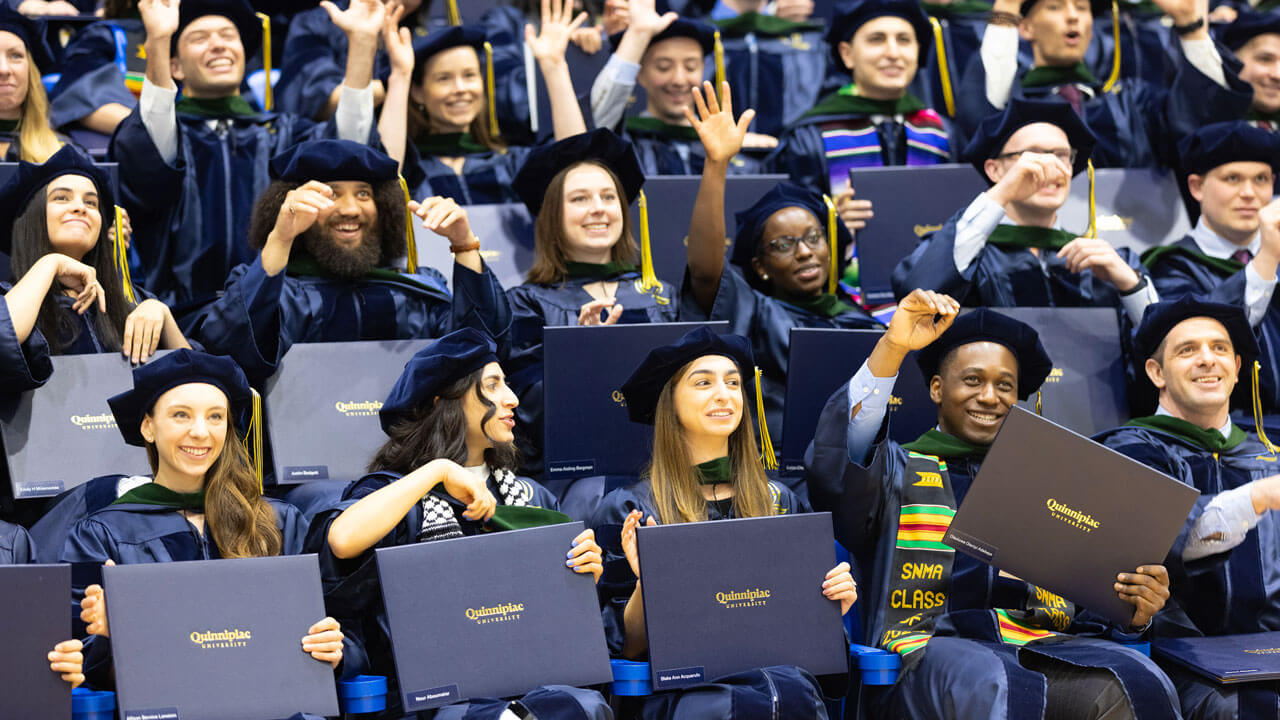 School of Medicine students posing for a photo with their diplomas