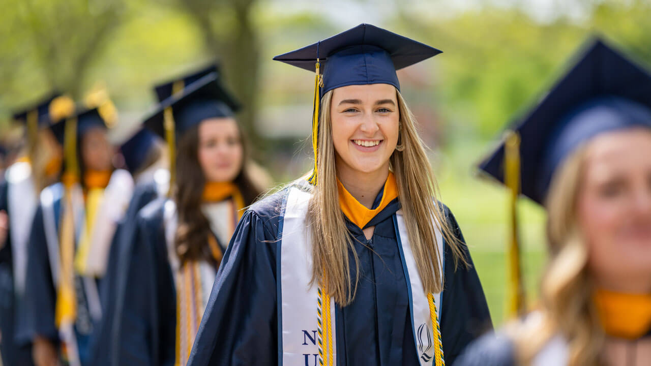 A proud Nursing graduate grins with excitement.