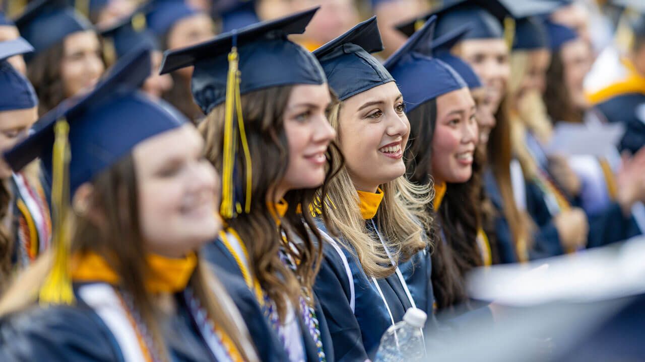 Graduates line up in a row smiling