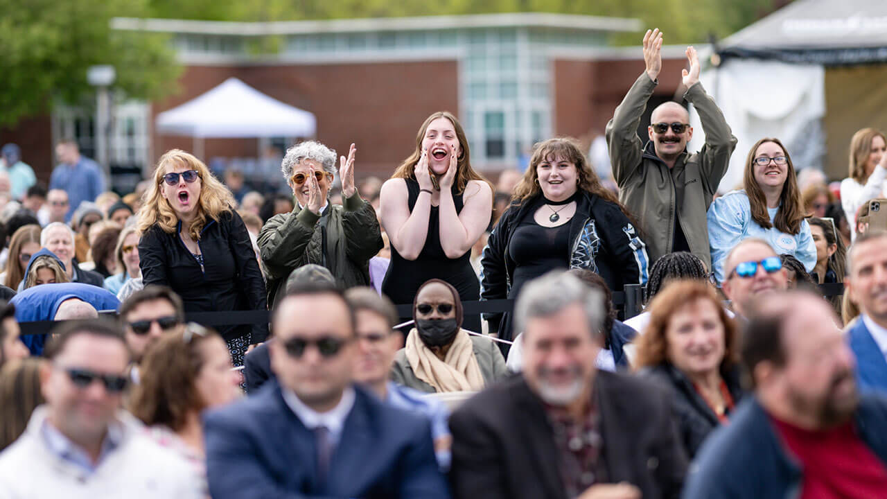 graduate's family and friends cheer and applaud