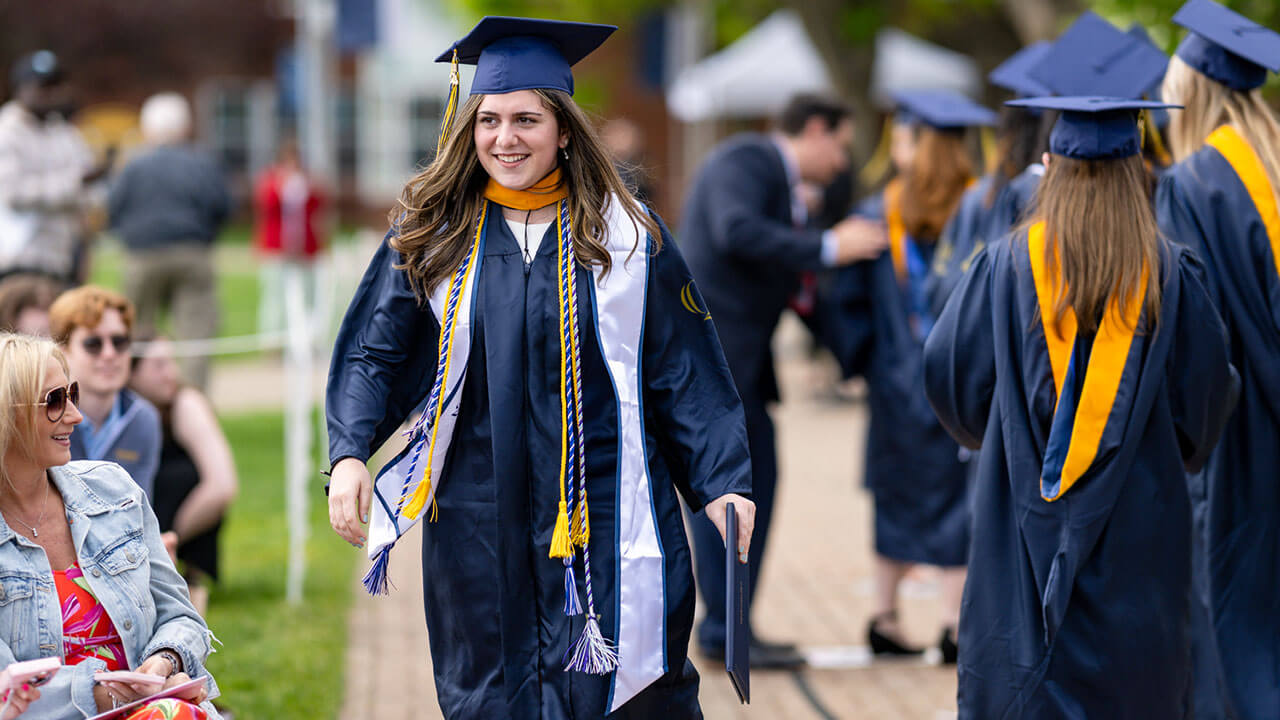 graduate walks back to the chairs