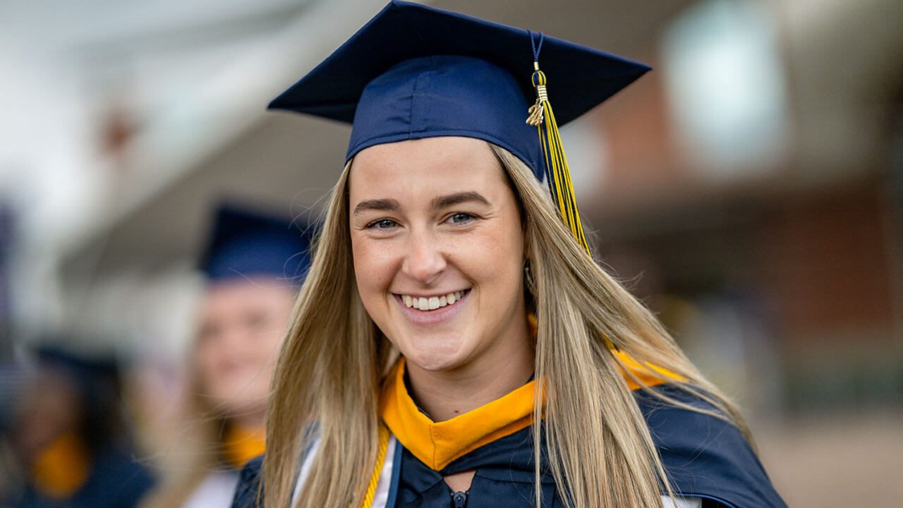 graduate smiles at camera