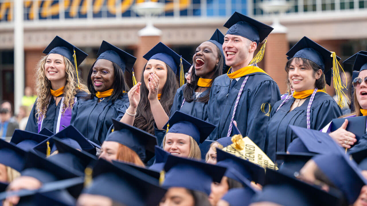 Quinnipiac graduates in the crowd stand and cheer