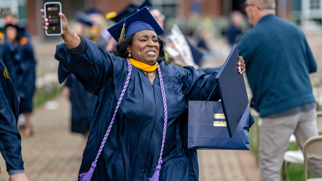 Graduate runs into the crowd happy crying holding her degree