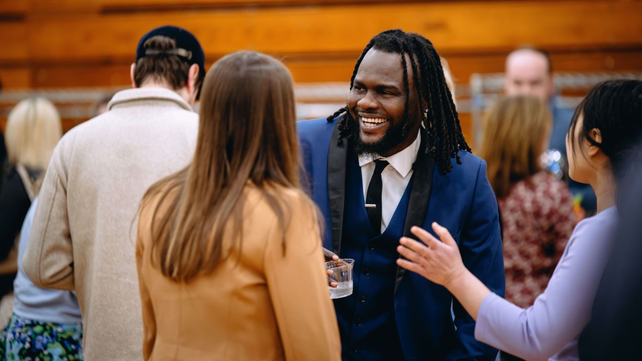 A medical school graduate smiles broadly with his family and friends