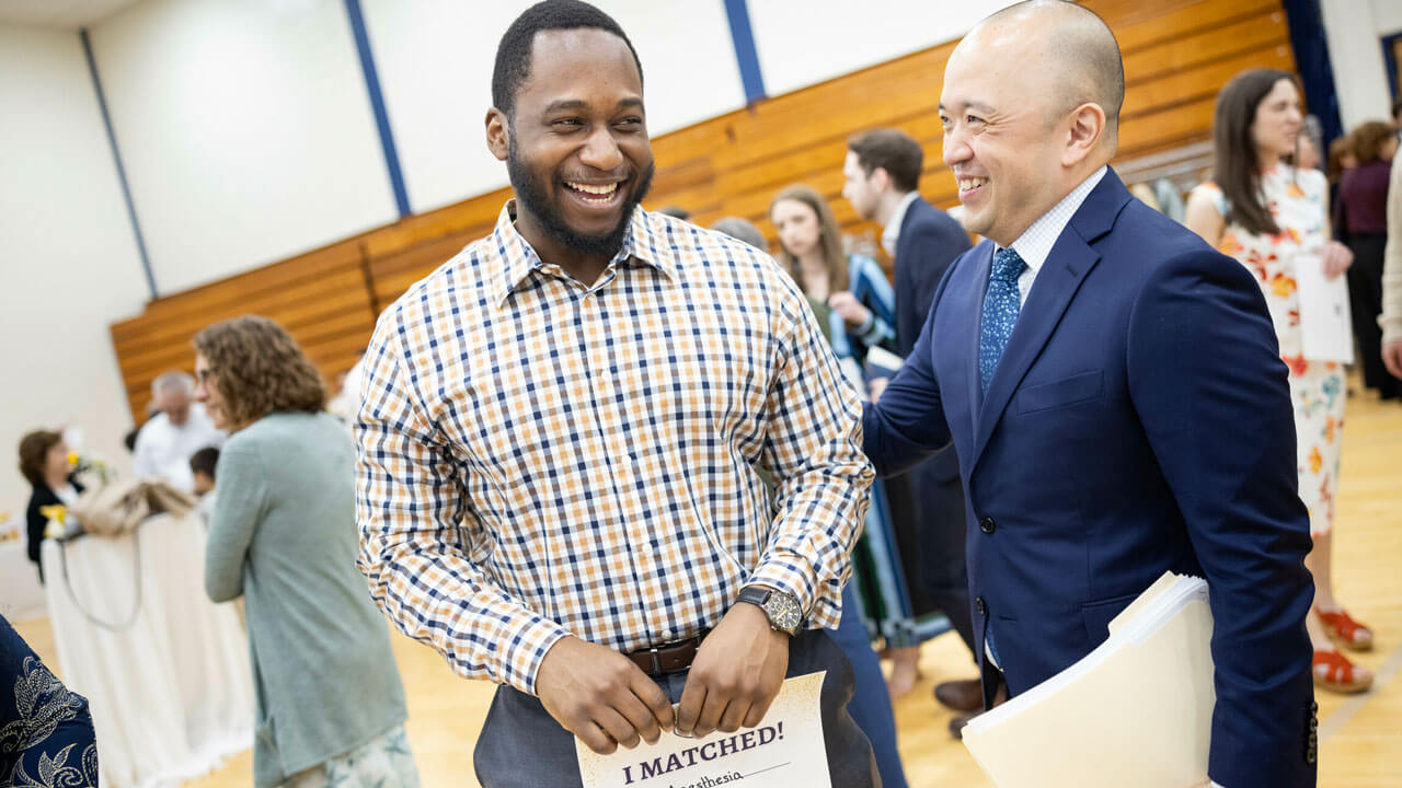 Steve Paik on the right, congratulates student on the left