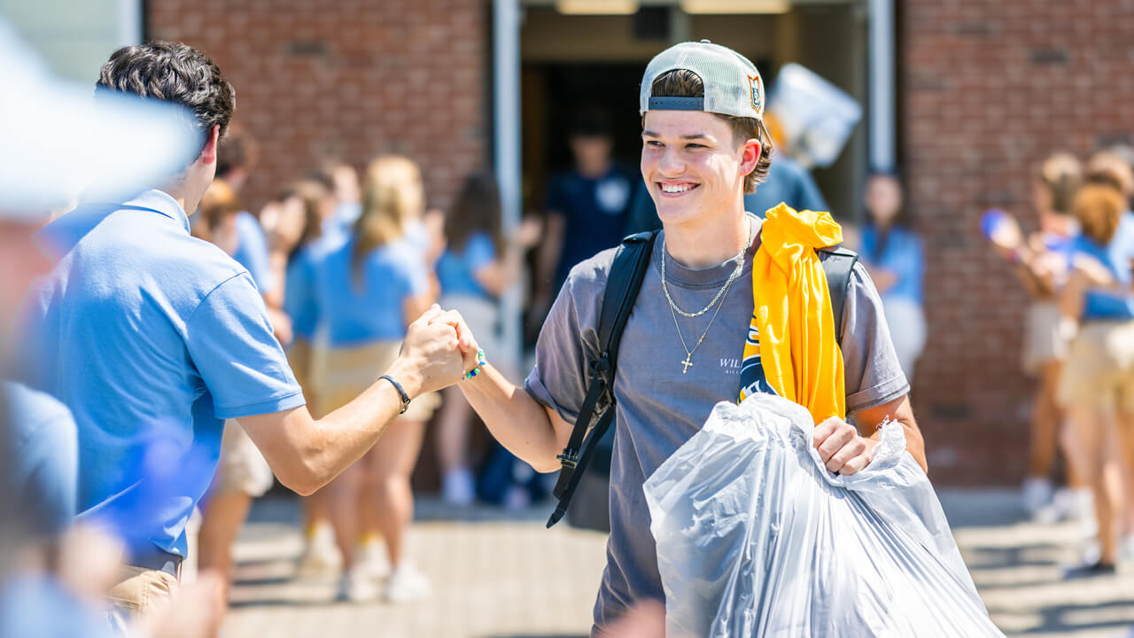 Two students fist-bump