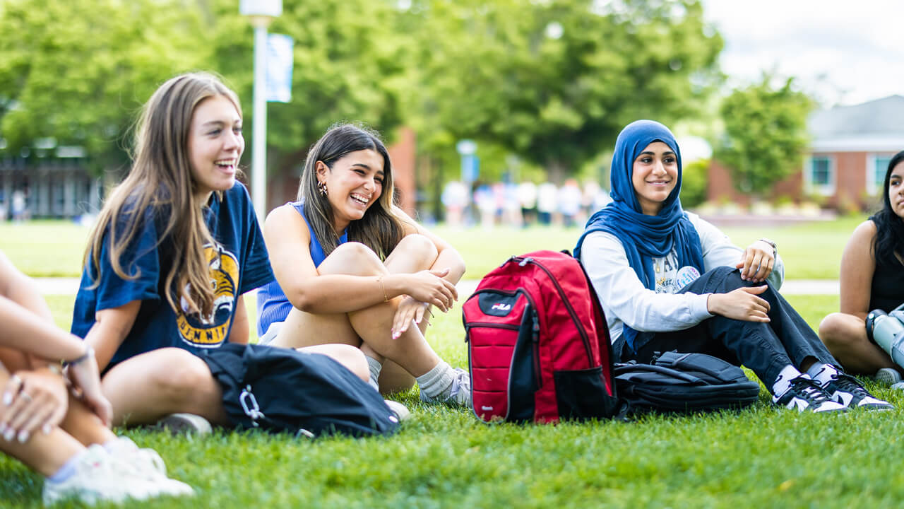 Students sit in the grass