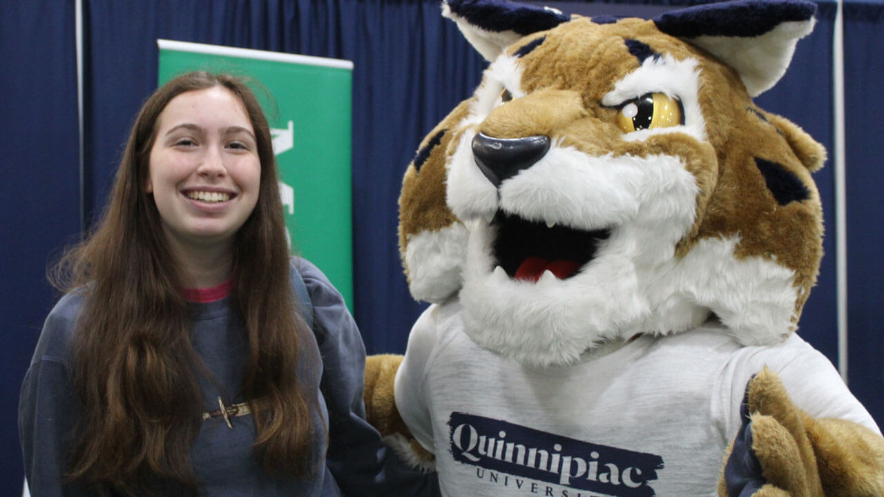 Orientation student smiles next to Boomer