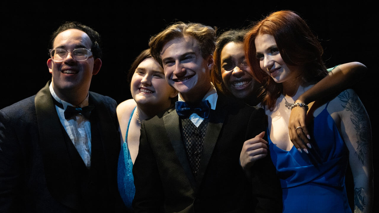 In the play Quinnipiac students pose from a photo at a prom