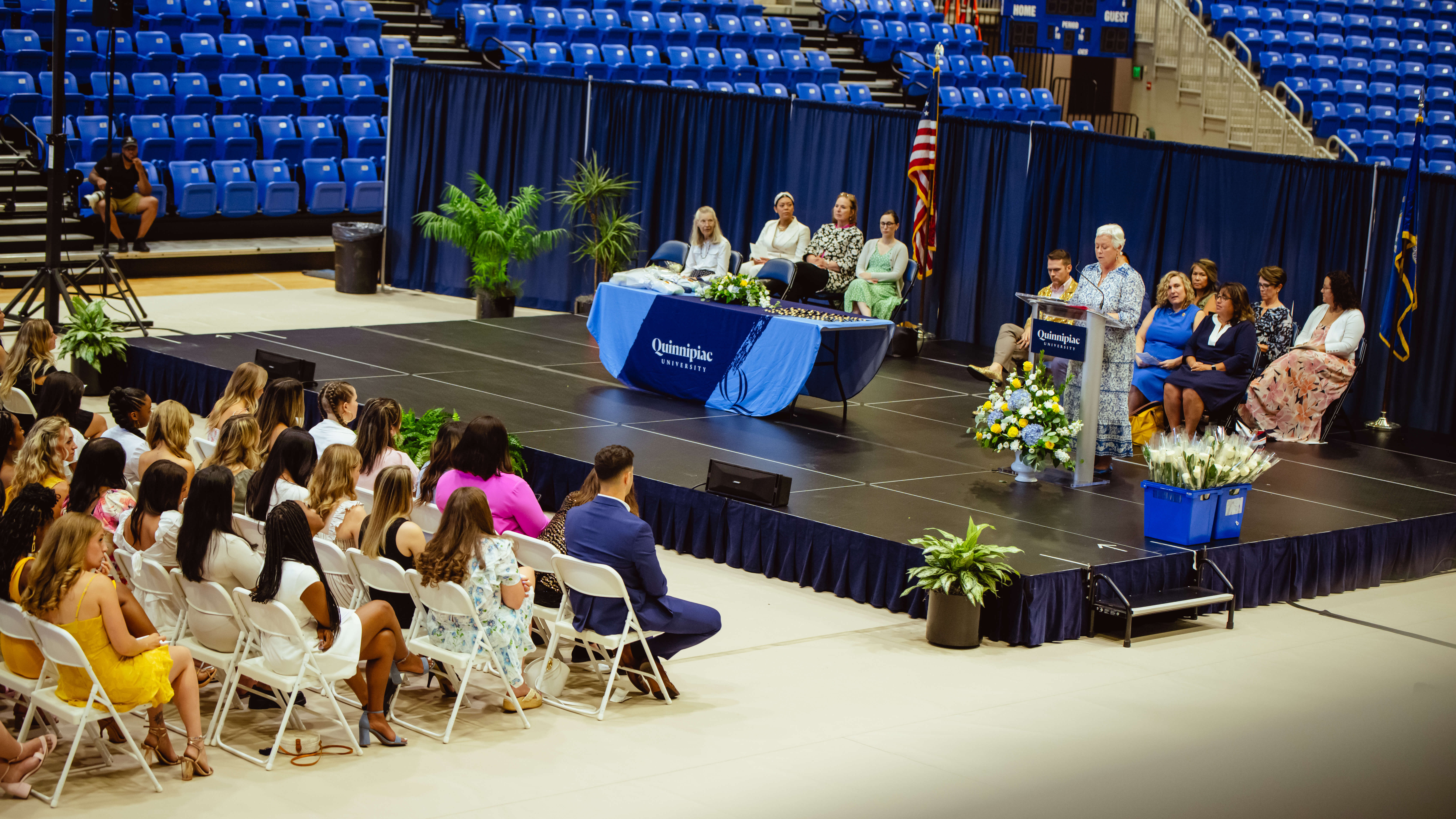 A birds-eye view of the stage and of graduates sitting in their seats