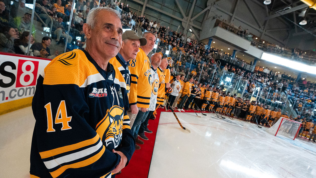 Alumni smile as they watch the banner raise