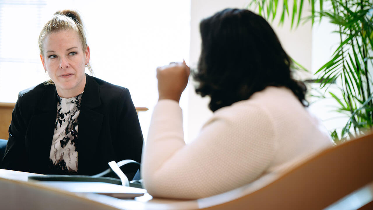 Two faculty members talk to each other.