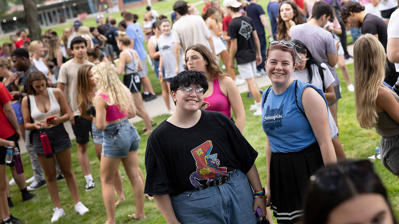 Hundreds of students talk and laugh on the quad in the sunshine