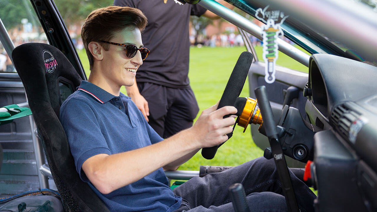 A student checks out a car on the Quad