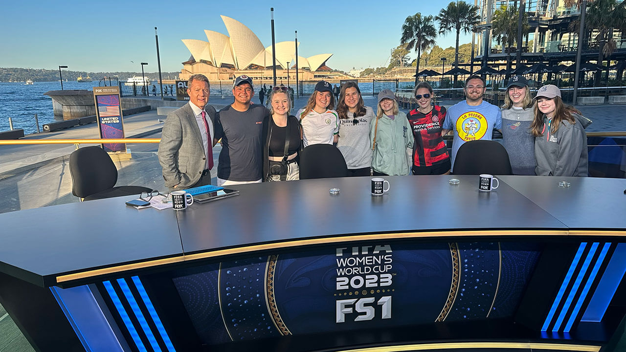 Students take a photo with Rob Stone,  a sports commentator for Fox Sports