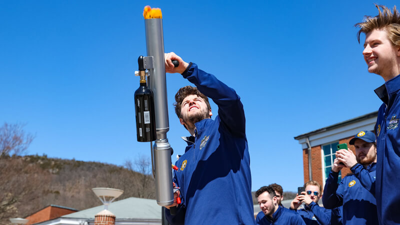 A members of the men's ice hockey team shoots a tee shirt from a cannon