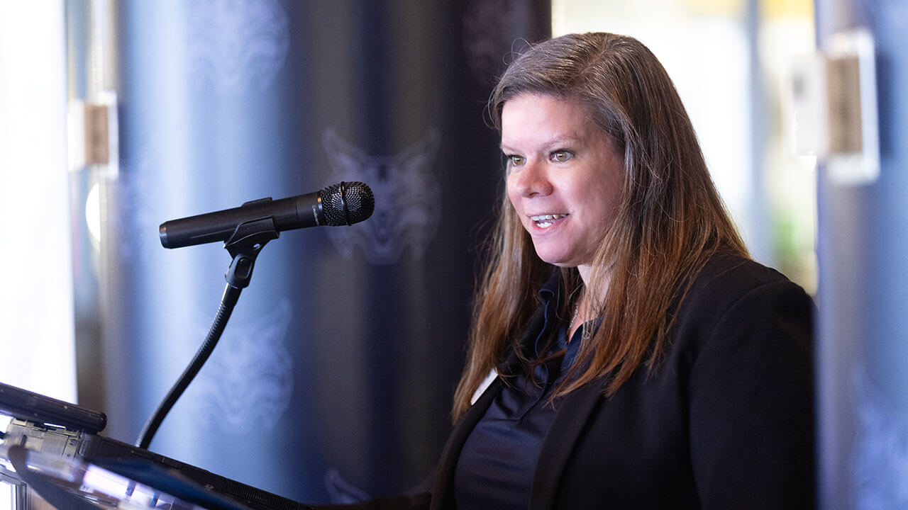 Speaker talking into a microphone at the Alumni Heritage Luncheon