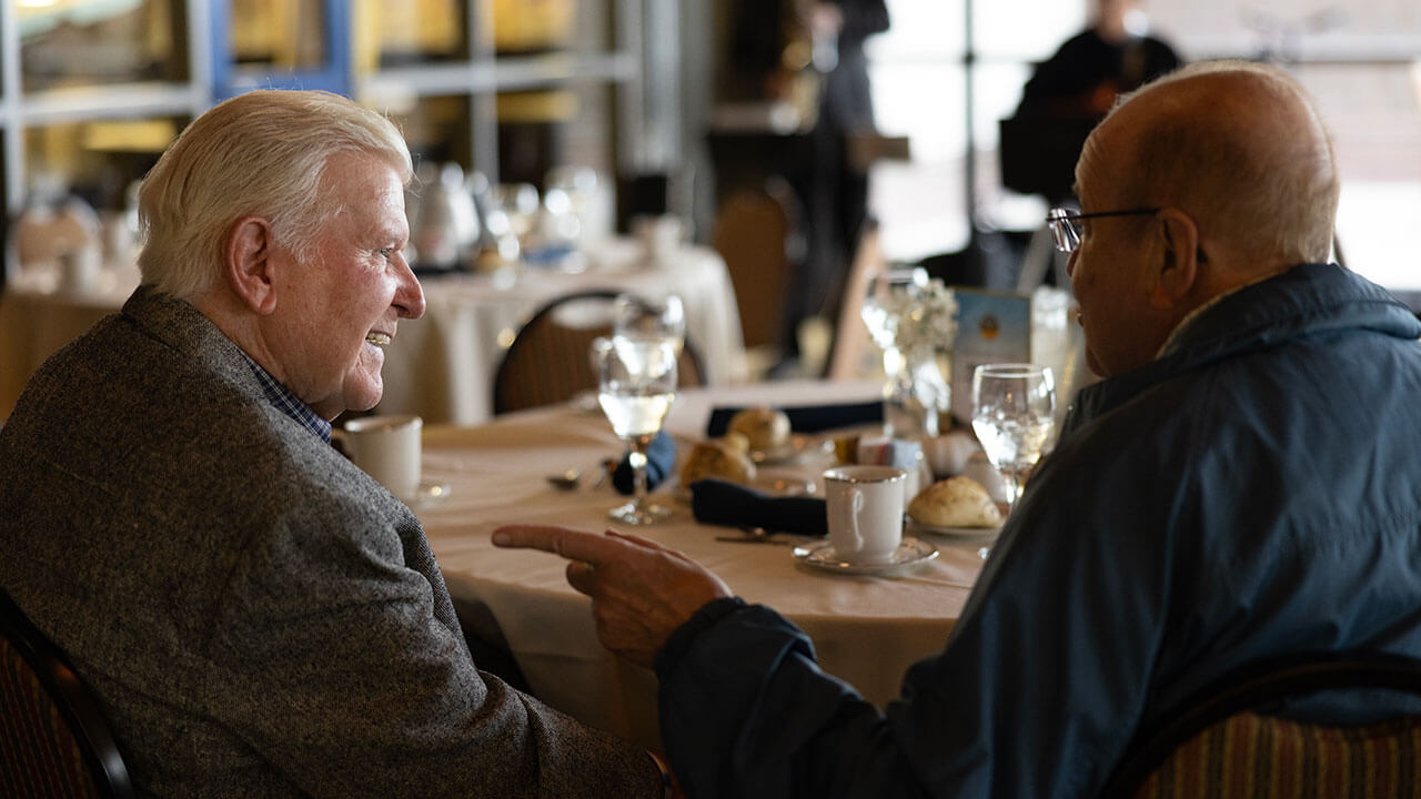 Alumni sitting down talking to each other at a table