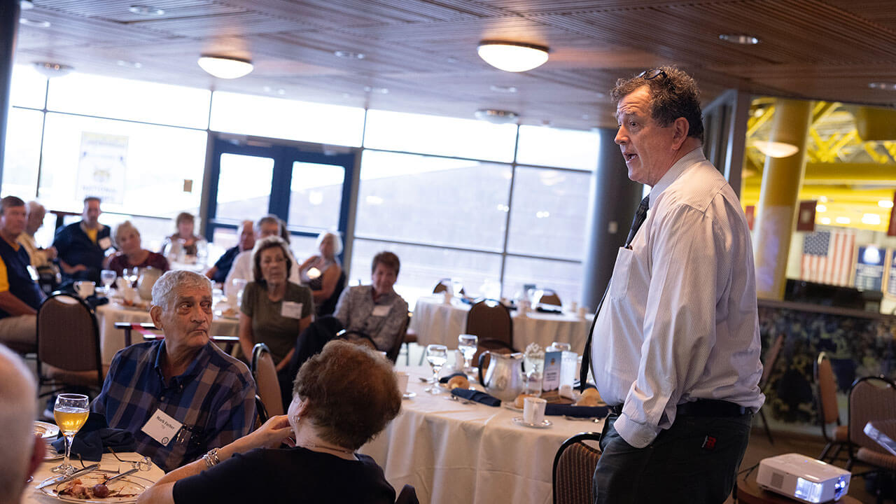 Speaker talking to a crowd of alumni at the Heritage Luncheon