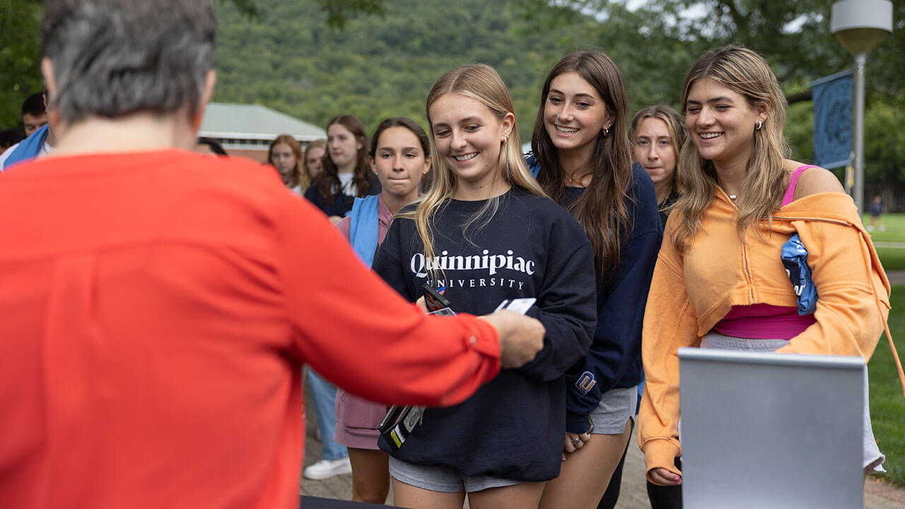 Girls smiling while being handed their Qcards