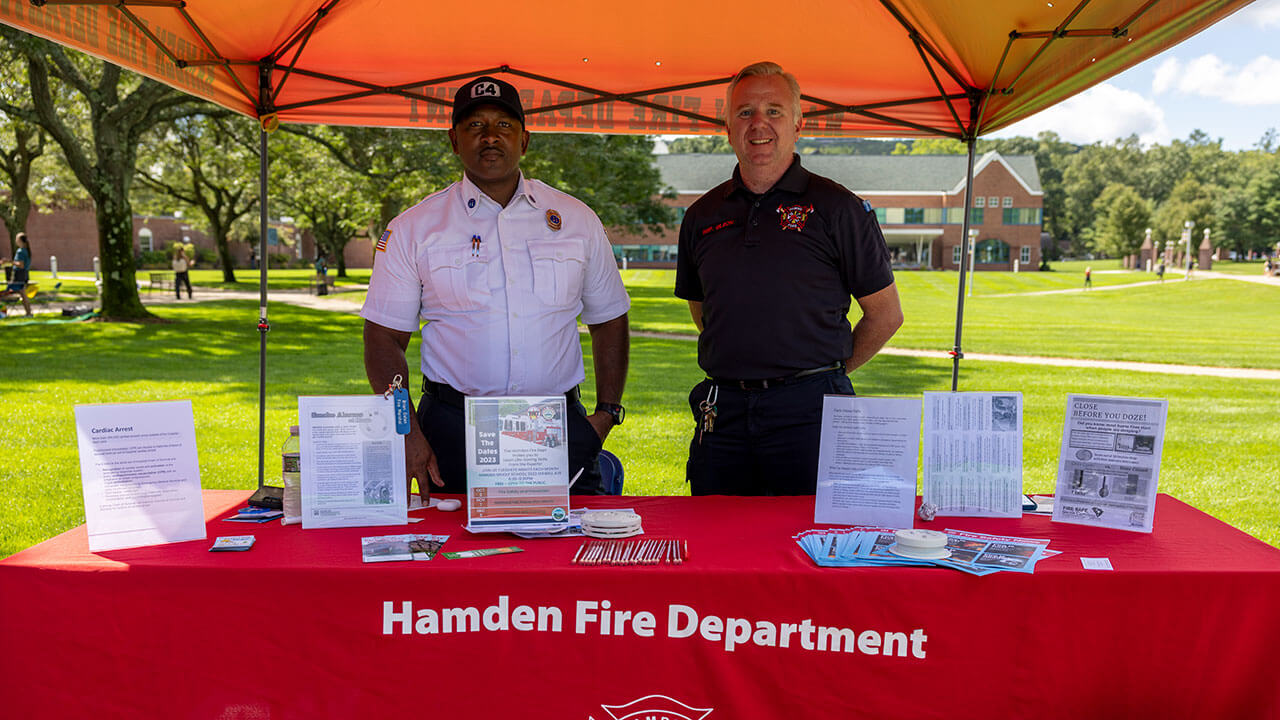 Hamden firemen smiling behind red tent