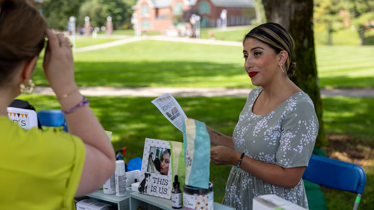 A student talks to a local business owner