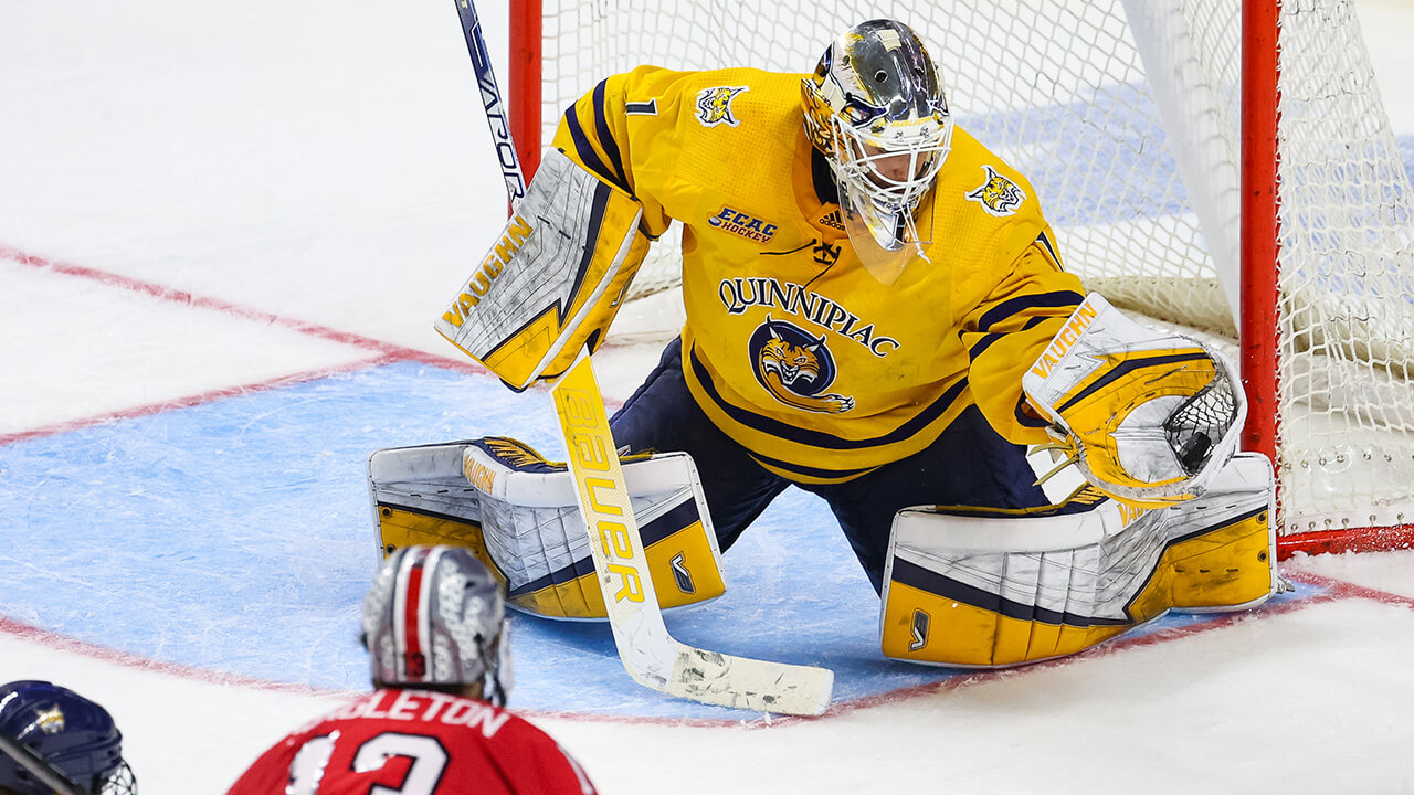 Men's Ice Hockey's goalie blocks a goal