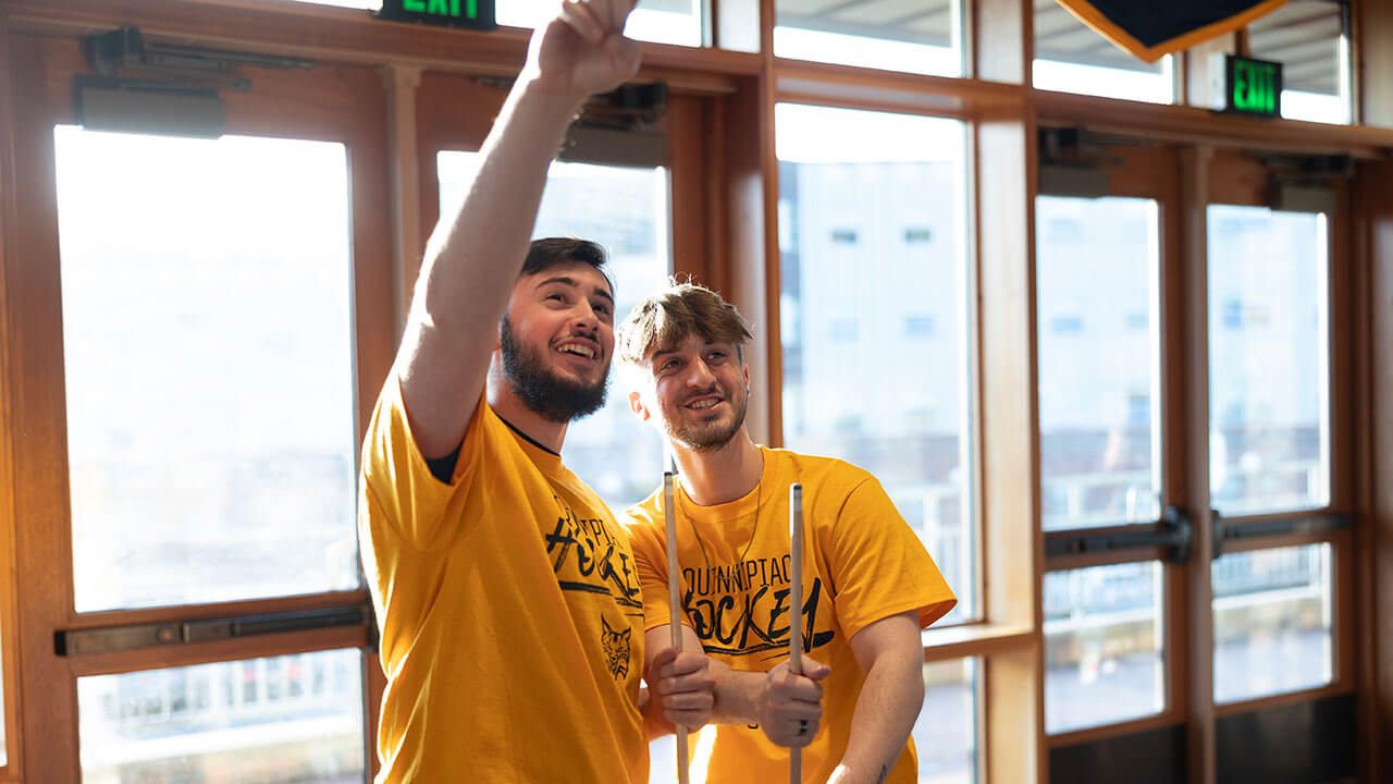 Students point to the hockey game playing at On the Rocks