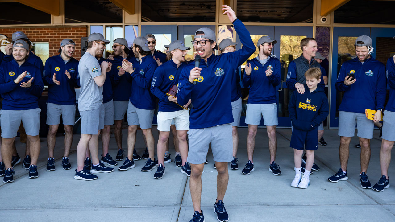 Teammate holding microphone and giving a speech