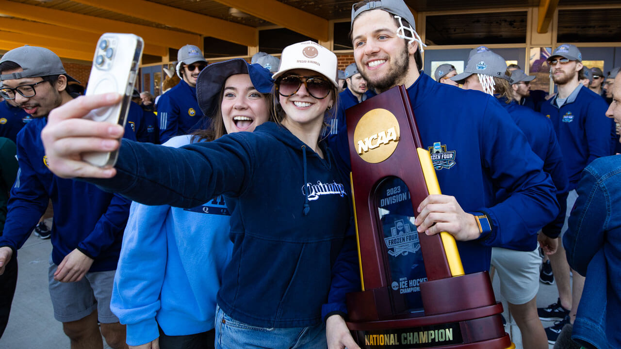 Team posing and taking photos with fans