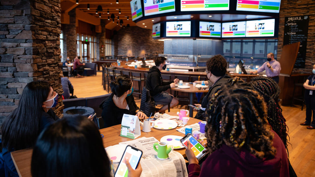 Several students play trivia using their phones in the pub