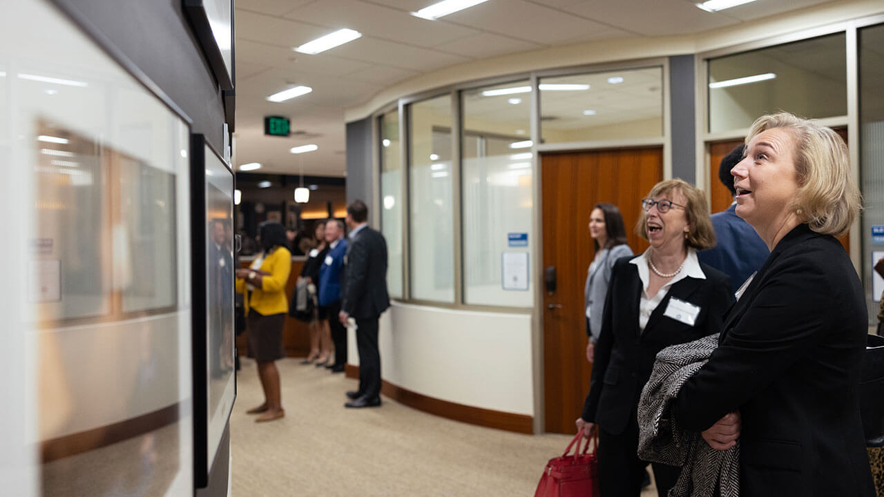 Two women admire the new Quinnipiac School of Law female judges exhibit