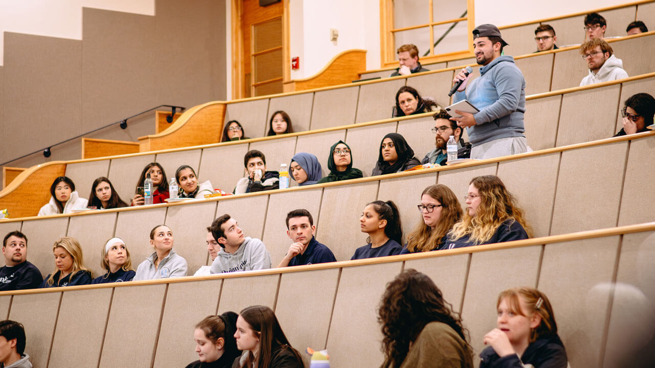 Rows of students in the Mount Carmel auditorium look at one another.