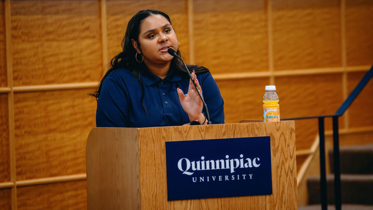 Vice President of the Student Government Association, Kay Owolabi, speaks at a podium.